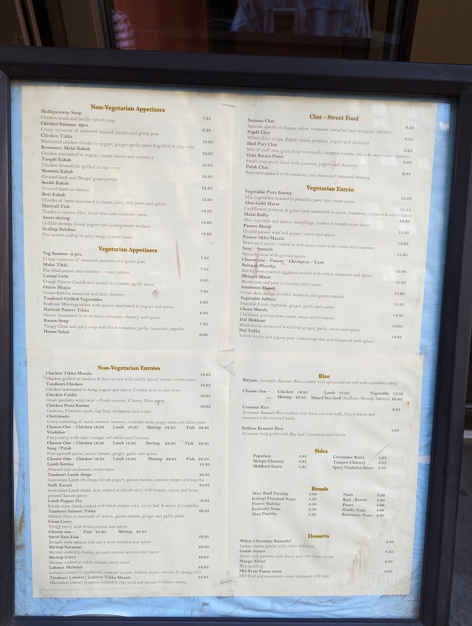 Printed menu with Indian dishes and delivery options.